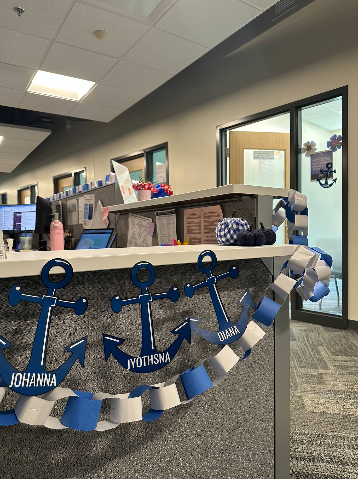 PCE Homecoming decorations, student worker names on anchors hung around the front desk